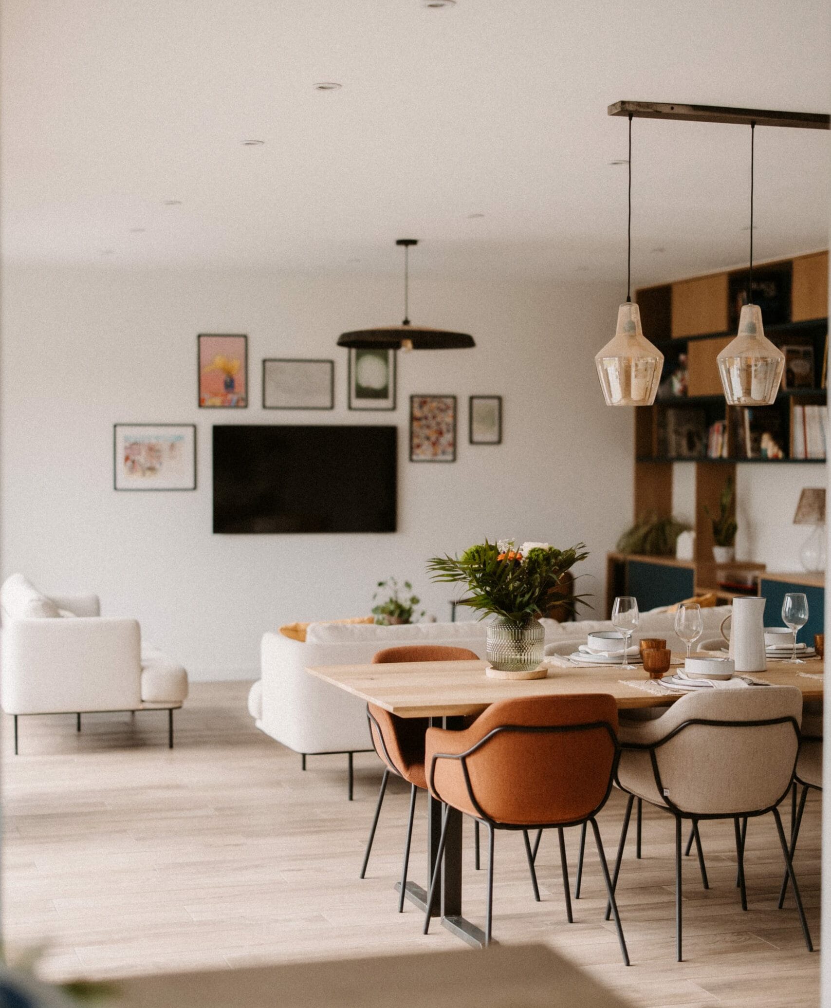 vue global sur un salon qui comporte une table à manger, un espace télé et des rangements